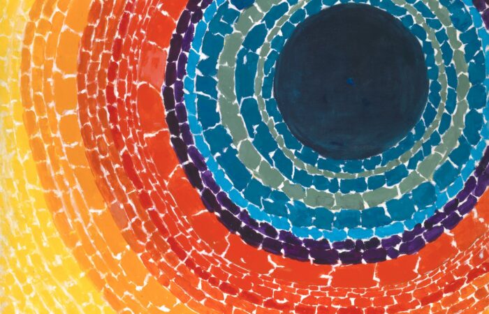 An abstract painting by Alma Thomas featuring concentric, circular rings of vibrant color radiating outward from a large, solid dark blue circle positioned in the upper right. Moving outward from the center, the concentric bands transition through shades of teal, deep blue, purple, bright red, orange, and finally a broad field of sunny yellow that fills the left and bottom edges of the canvas.