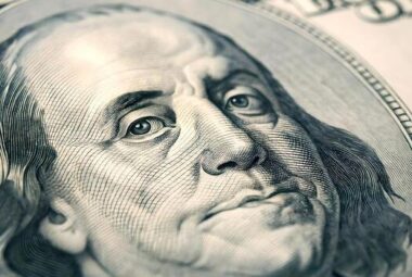 A zoomed in photo of Benjamin Franklin's face on the 100 dollar bill.
